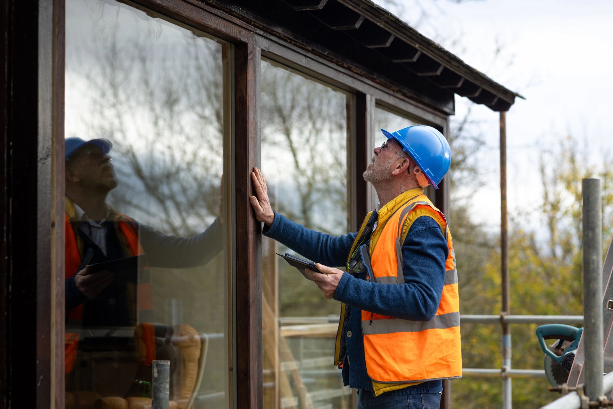 Inspector reviewing exterior window condition at a home