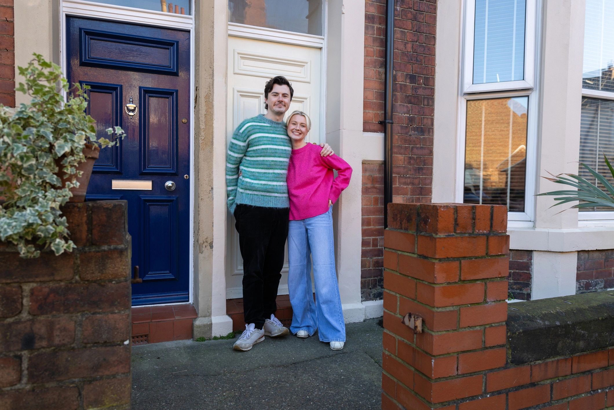 Homeowners standing outside a home, representing confidence after a professional inspection